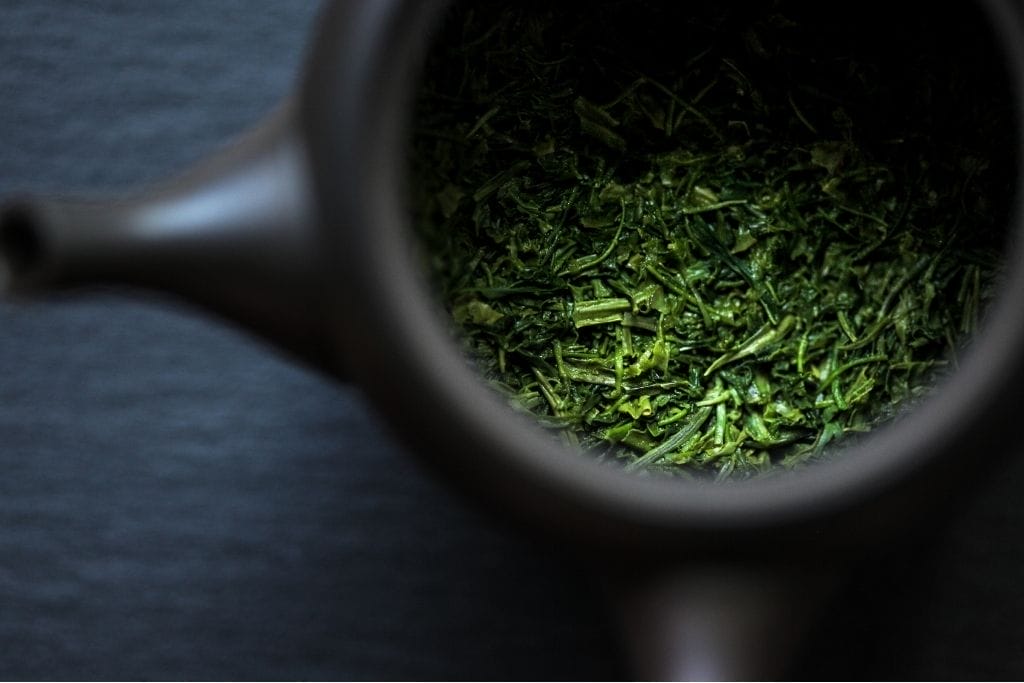 Grüner Tee Teeblätter in schwarzer Kyusu Teekanne für traditionelle Zubereitung
