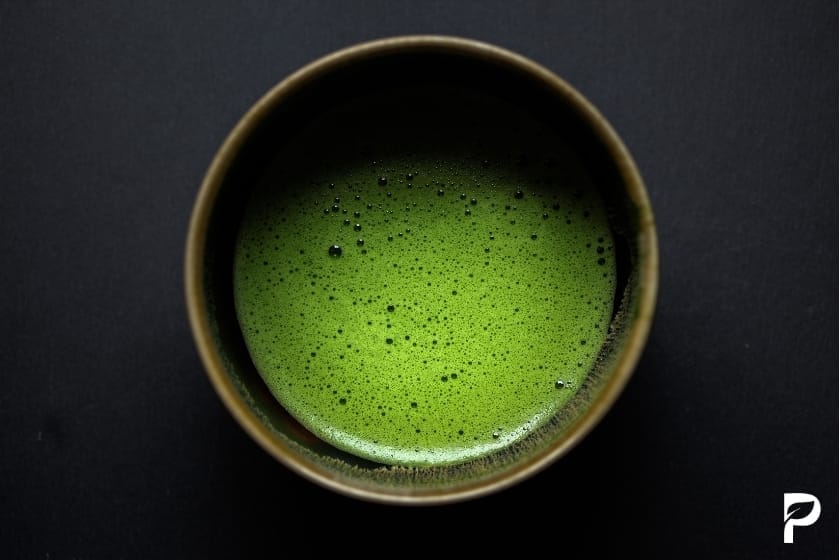 Japanische Matcha Zubereitung mit Bambusbesen in traditioneller Teeschale

